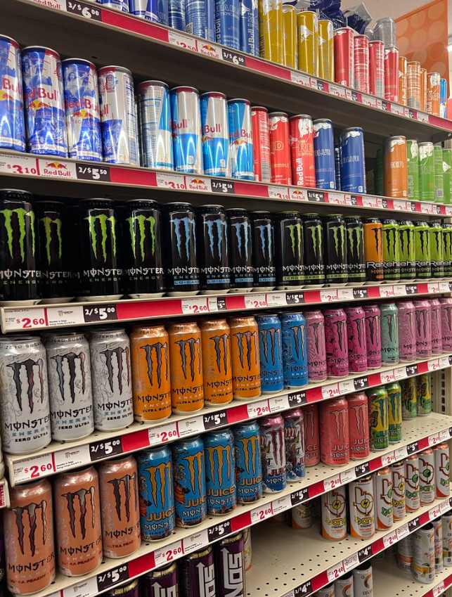 Crowded retail shelf filled with many energy drink cans
