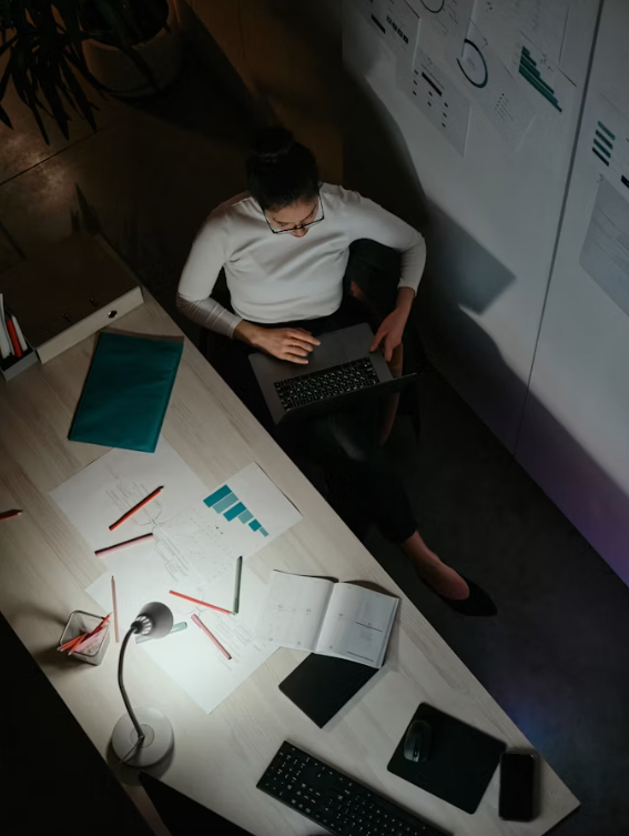 Person working late at a laptop in a dark office setting